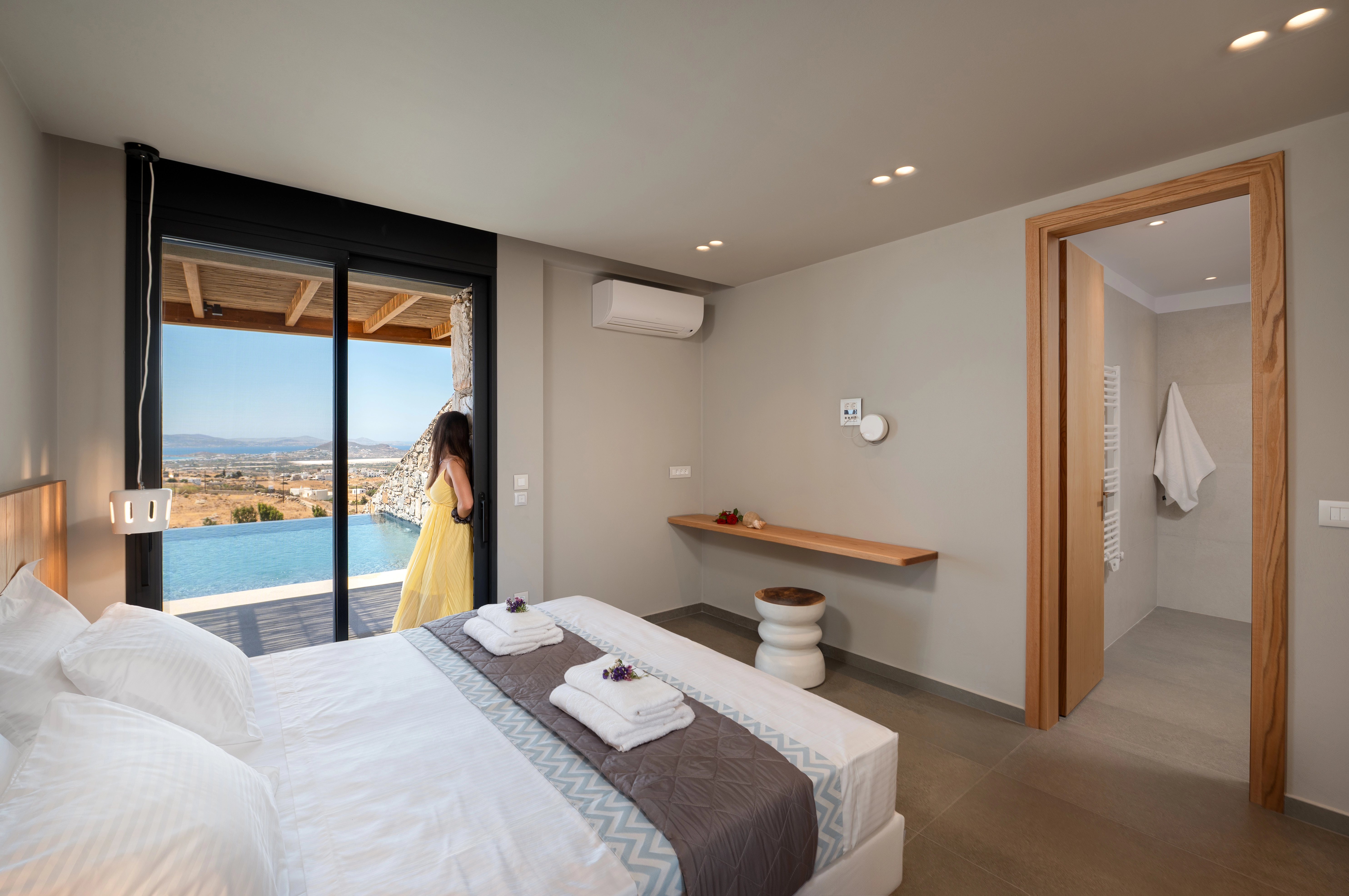 Woman looking outside of the villa from the bedroom